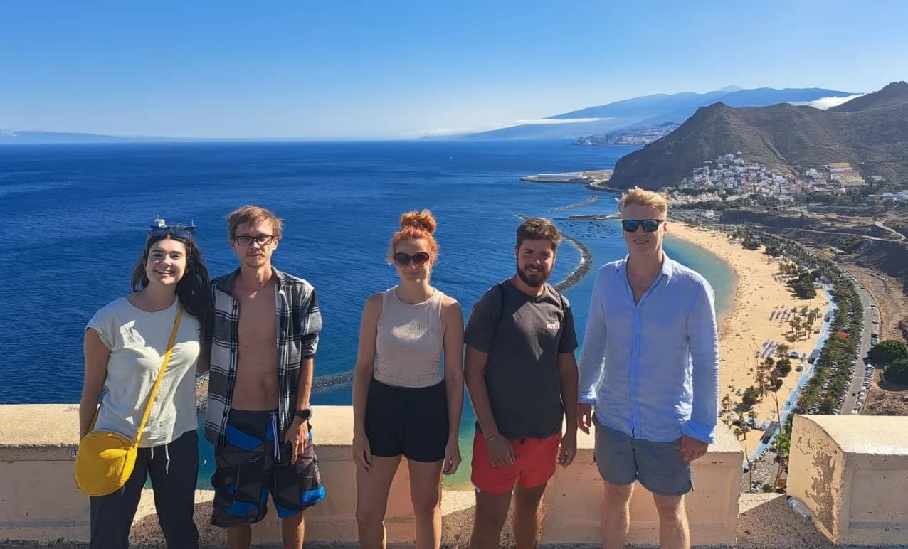 Five colivers at a viewpoint above Las Teresitas beach, with the Atlantic and San Andrés behind