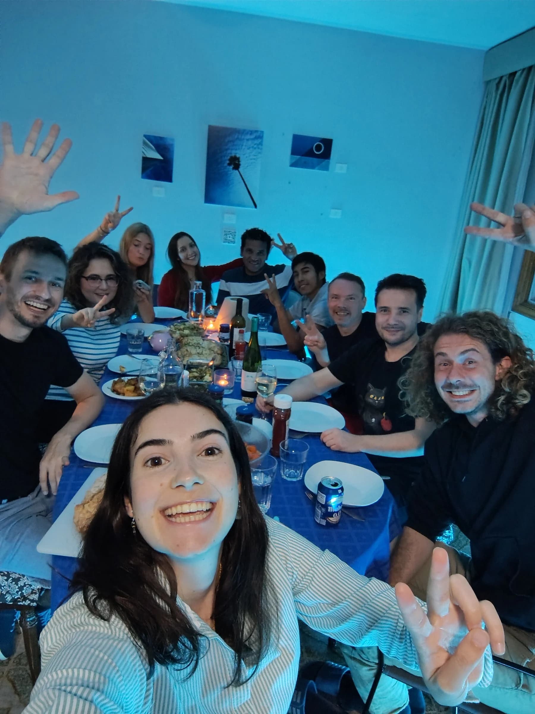 Colivers smiling and making playful gestures around a shared dinner table at Blue Paradise