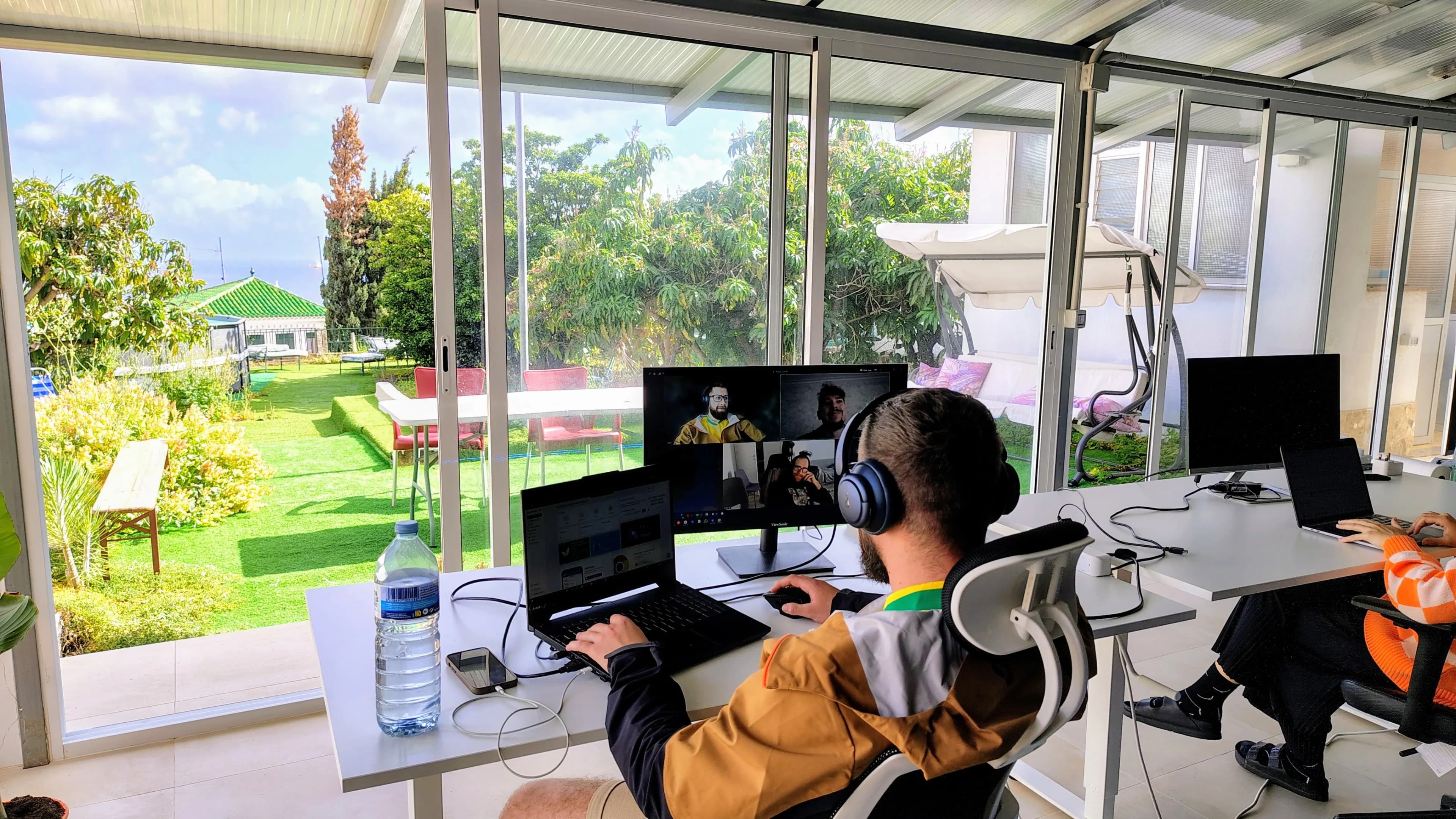 Coworking de Blue Paradise con escritorios, monitores y ventanas hacia el océano.