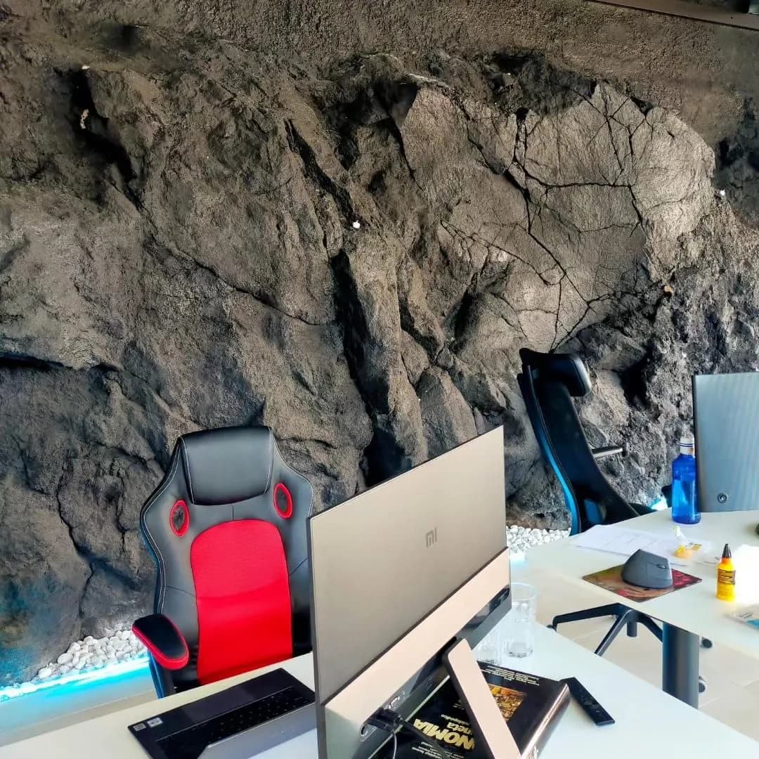 Coworking interior con una pared de roca volcánica.
