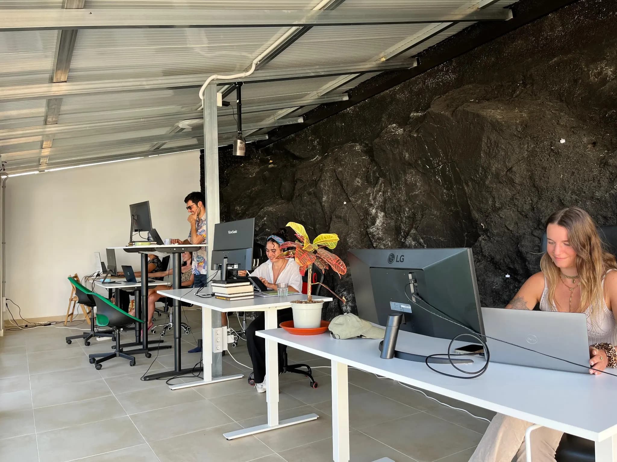 Escritorios tranquilos junto a la pared de roca volcánica.