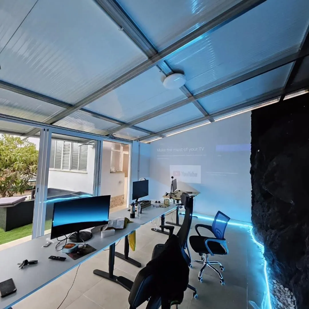 Sala de coworking con monitores y textura de roca volcánica.