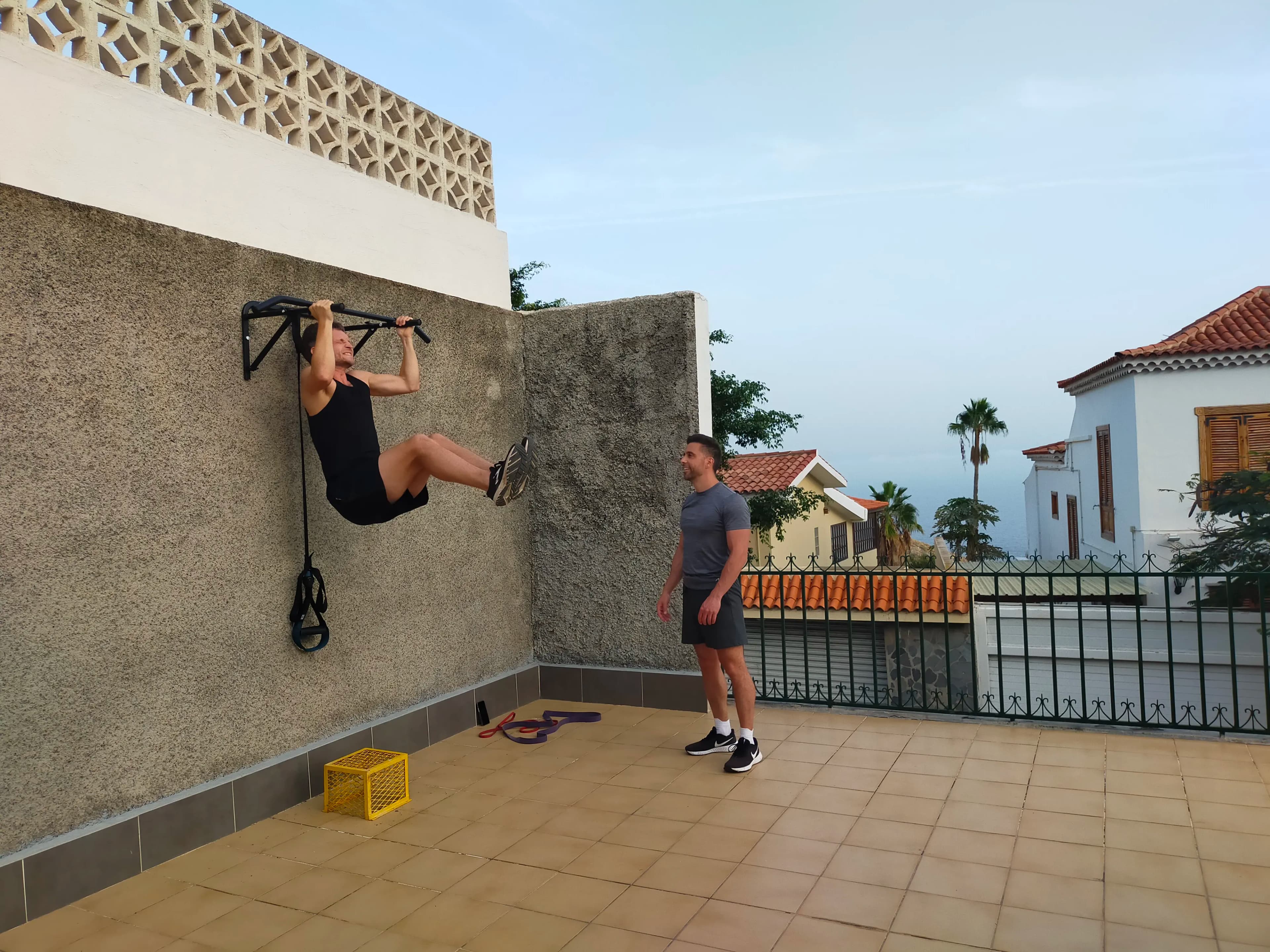 Terrasse fitness extérieure avec ping-pong, TRX et vélo stationnaire.
