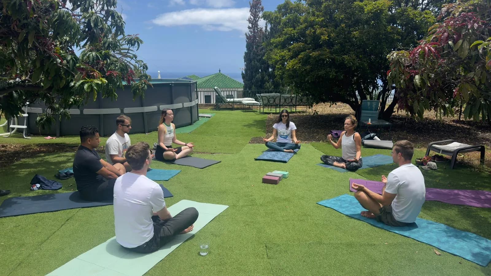 Les colivers de Blue Paradise pratiquant une séance de bien-être en plein air dans le jardin.