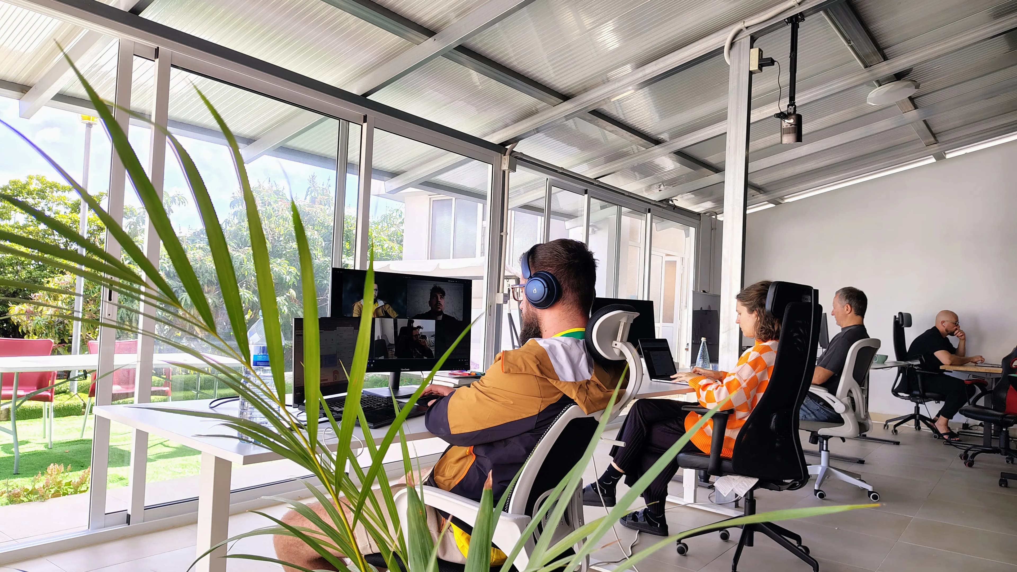 Sea-view coworking space with desks, monitors, and natural light.
